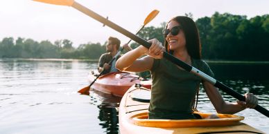 Two people kayaking on calm water.