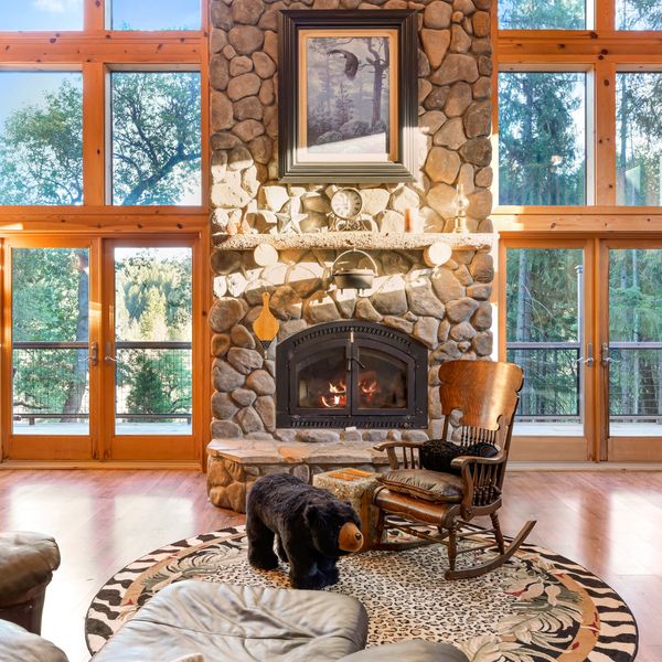 Cozy living room with stone fireplace and rocking chair.