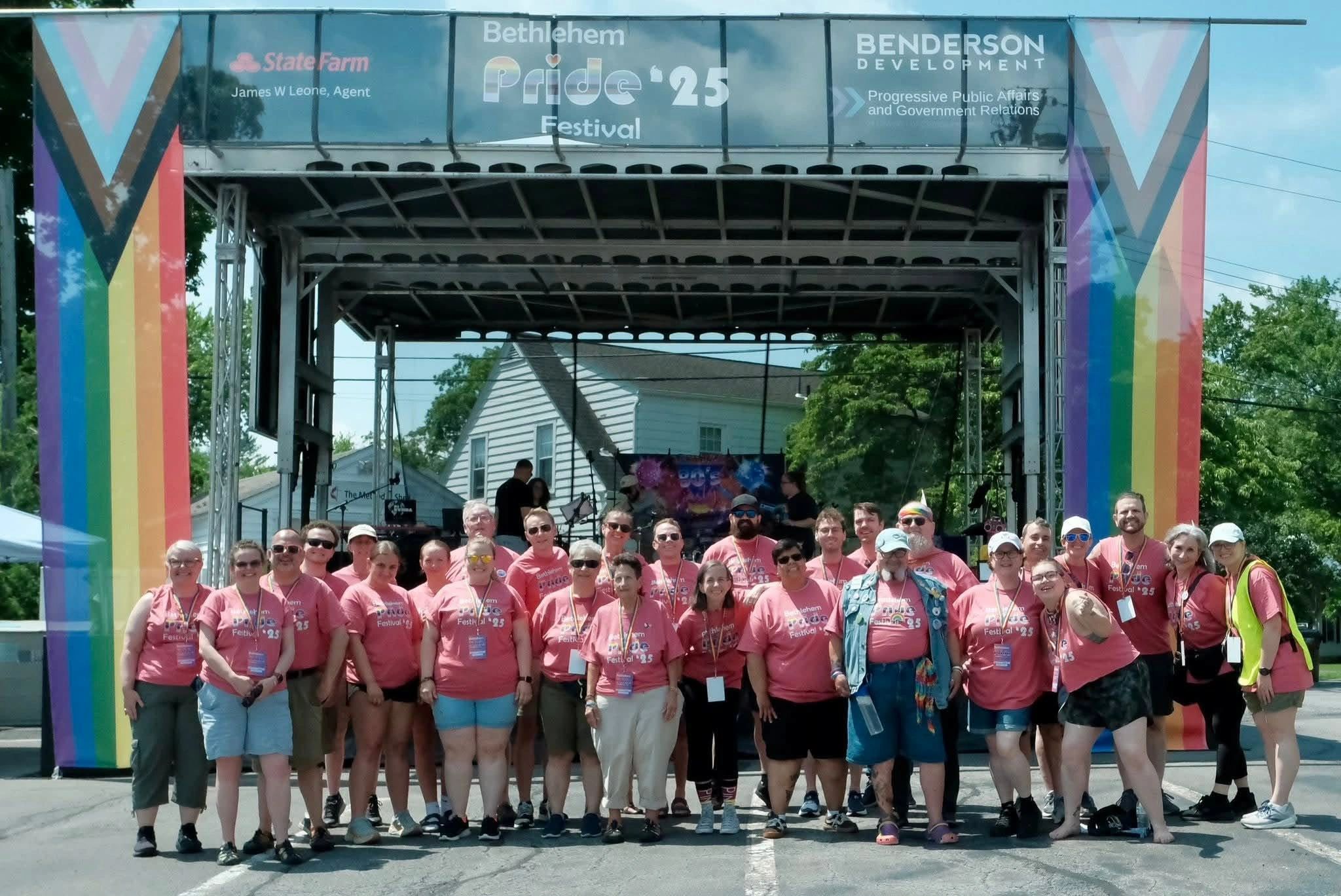 Group of people posing at Bethlehem Pride Festival 2025 under rainbow-colored banners.