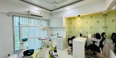 Modern dental clinic with green accents and sleek white furniture.