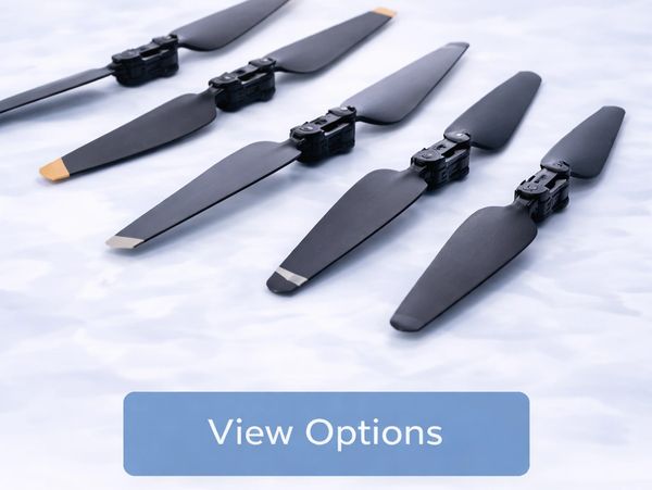 Various black drone propellers arranged in a row on a white surface.