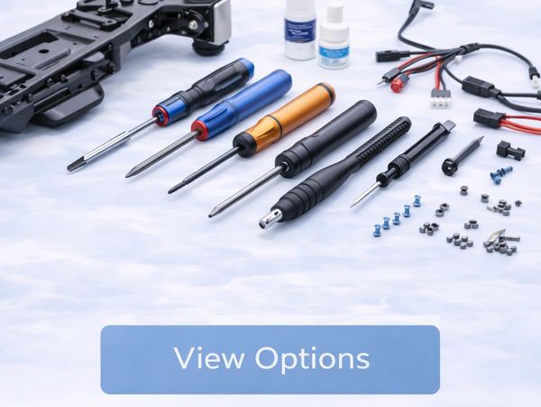 Set of precision screwdrivers and small electronic components on a light surface.
