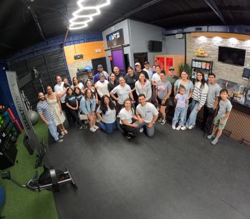Group photo of people in a gym or fitness studio with exercise equipment.