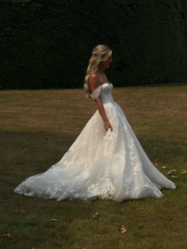 Woman in elegant white wedding dress outdoors.