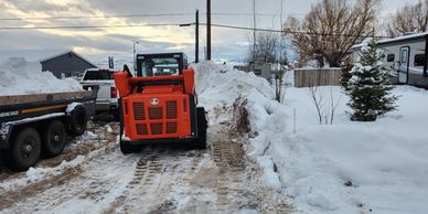 Snow removal equipment clearing a residential driveway in Star Valley, Wyoming.
