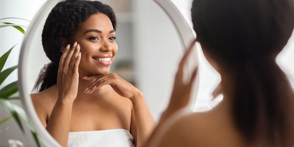 Woman smiling at herself in the mirror.