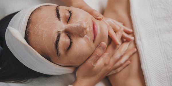 Woman receiving a facial massage at a spa.