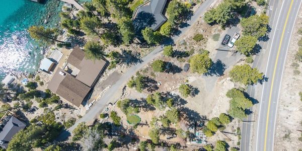 Aerial view of houses near a lake with a road passing by.