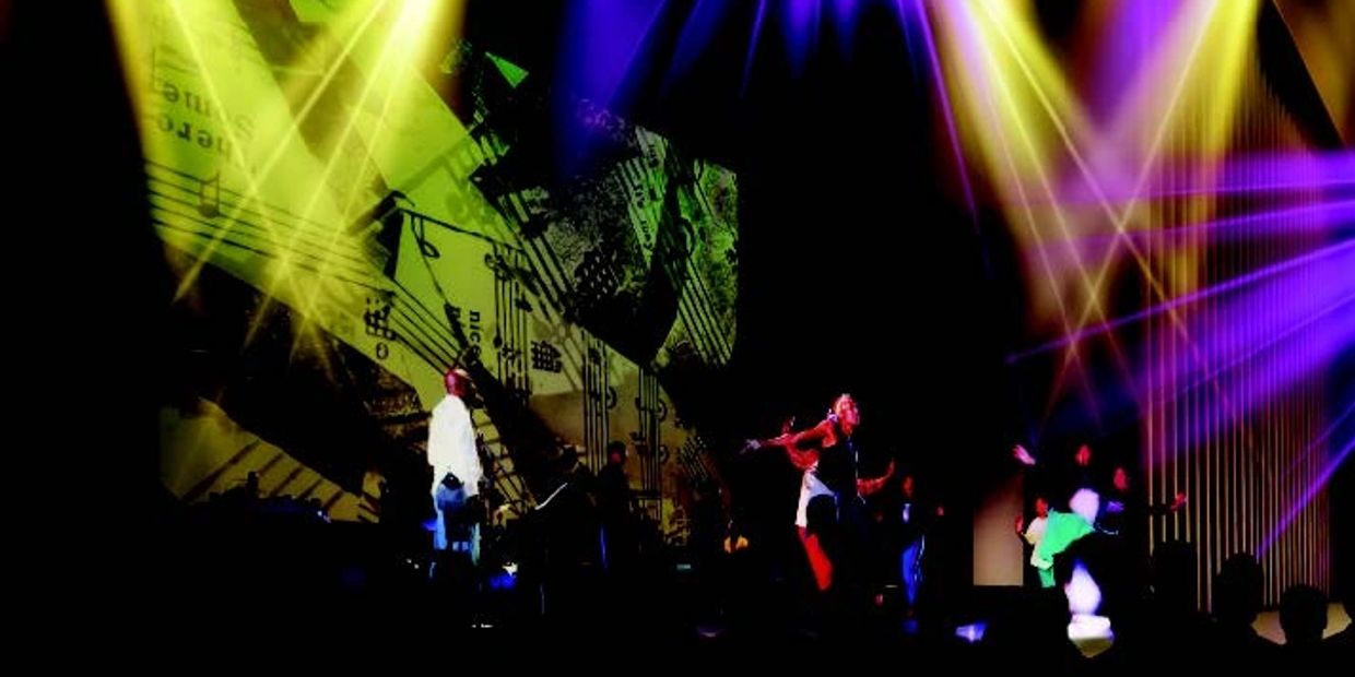 Colorful stage lights illuminate performers against a backdrop of musical notes.