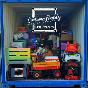 A packed storage container with various household items and toys inside.