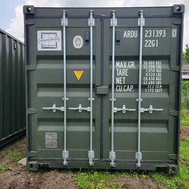 Green shipping container with labeling and secure locking mechanisms.