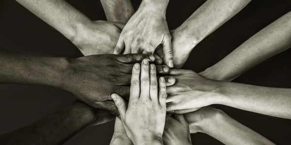 Diverse hands stacked together in unity.