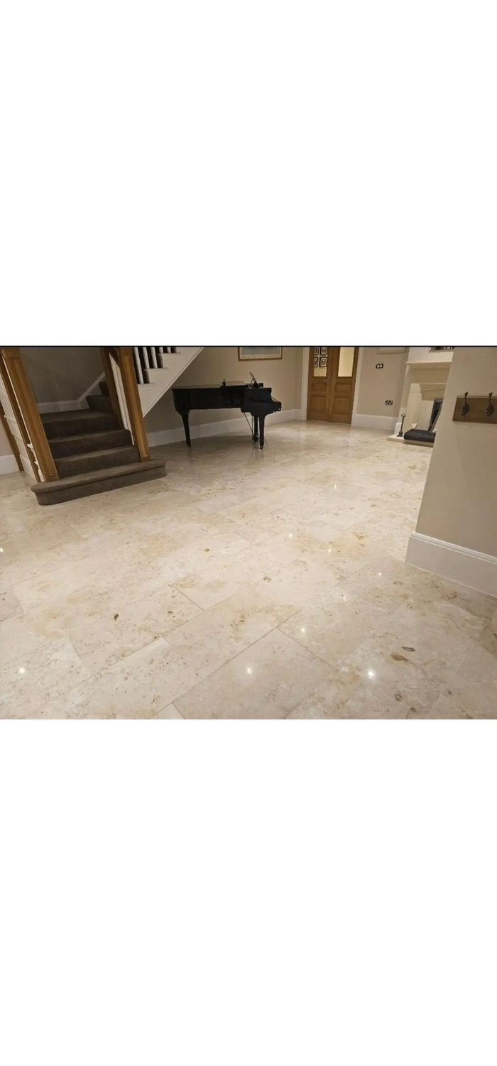 Elegant interior with polished marble floors and a grand piano under the staircase.