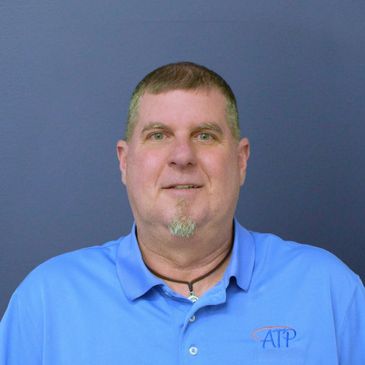 Man in a blue ATP polo shirt against a plain background.