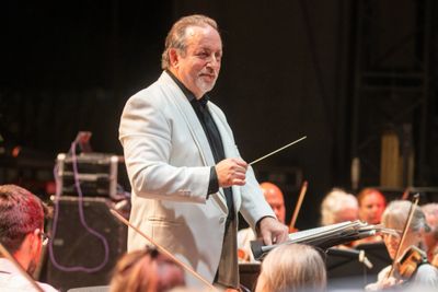 Conductor leading an orchestra during a live performance.