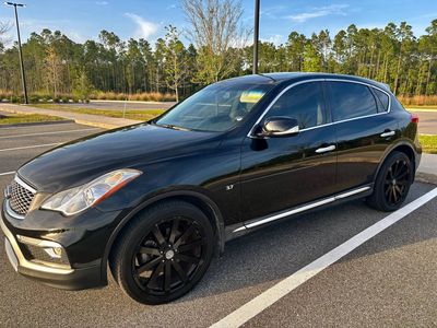 Black luxury SUV parked in an outdoor lot with large black wheels.