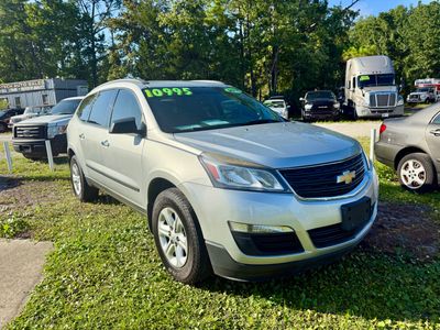 Silver Chevrolet SUV parked on grass with price $10,995 on windshield.