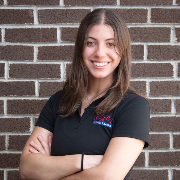 Young woman smiling with arms crossed.