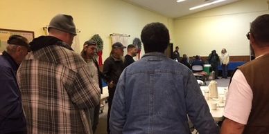 Before dinner is served, the homeless men and women join hands with the pastor in prayer.