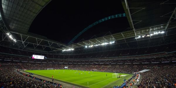 A nighttime football match in a large stadium packed with spectators.