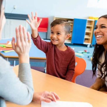 A child doing a high-five with an adult.