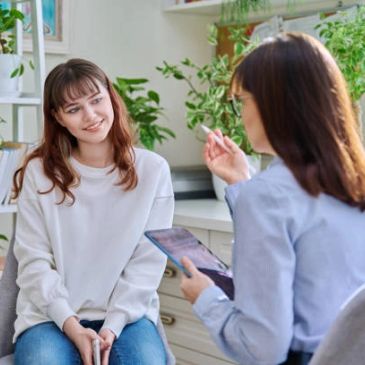 A woman and a teen are having a therapy-related conversation.
