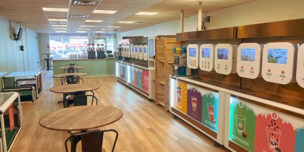Modern self-serve frozen yogurt shop with multiple dispensers and seating.