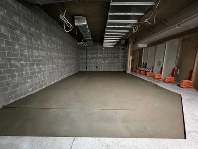 Newly poured concrete slab inside a construction site room.