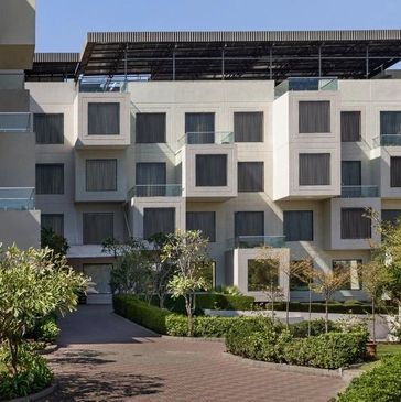 Modern building with cubic balconies and greenery.