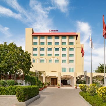 Front view of Ramada hotel building with clear sky.