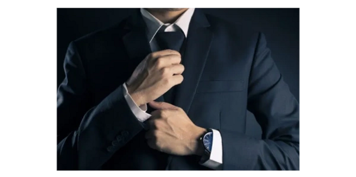 A man fixing his tie.