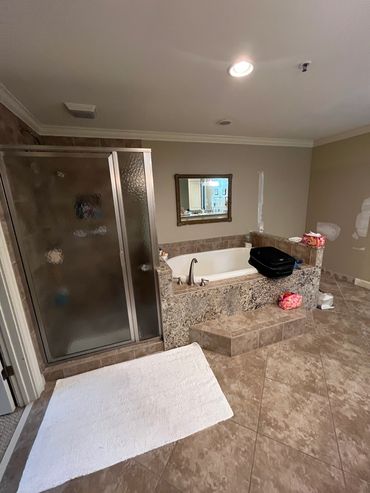 Vinings master bathroom before remodeling dated built-in tub, shower, and old stone tile floor.