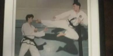 Two martial artists sparring indoors.