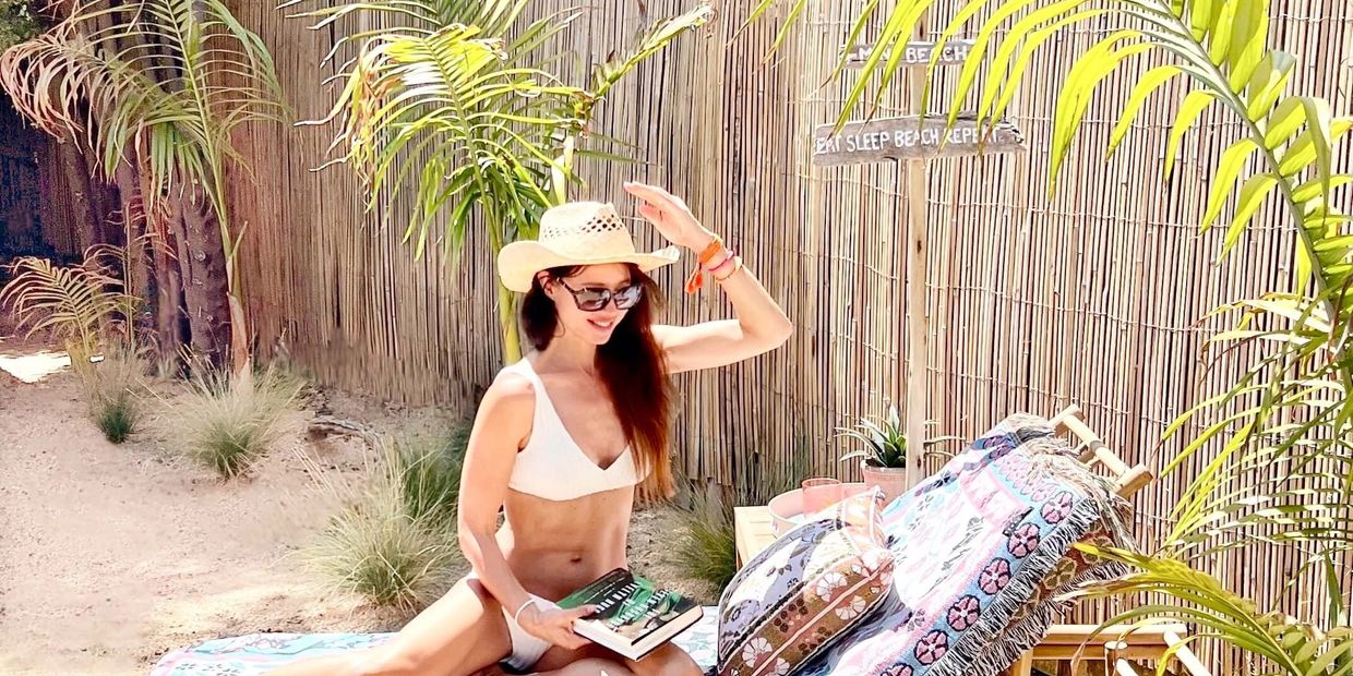 Bamboo sunlounger with girl in straw hat and bikini