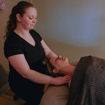 Therapist giving a relaxing neck massage to a client.