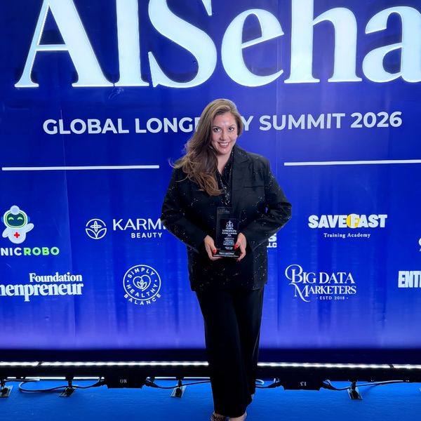 Woman holding an award at the Global Longevity Summit 2026.