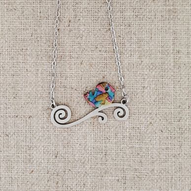 Necklace with a colorful bird pendant on a silver swirl design.