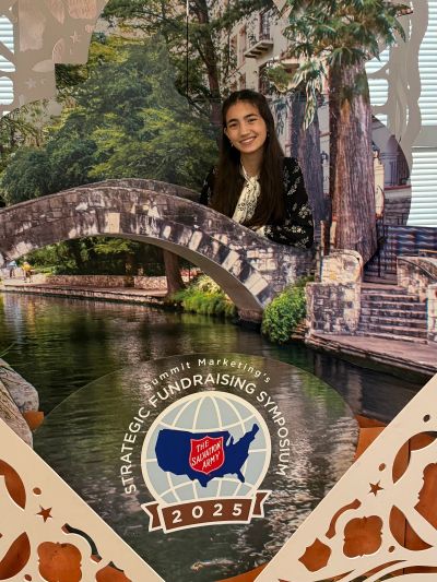 Young woman smiles at a fundraiser symposium photo booth.