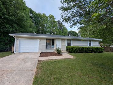 Single-story house with a garage and green lawn.