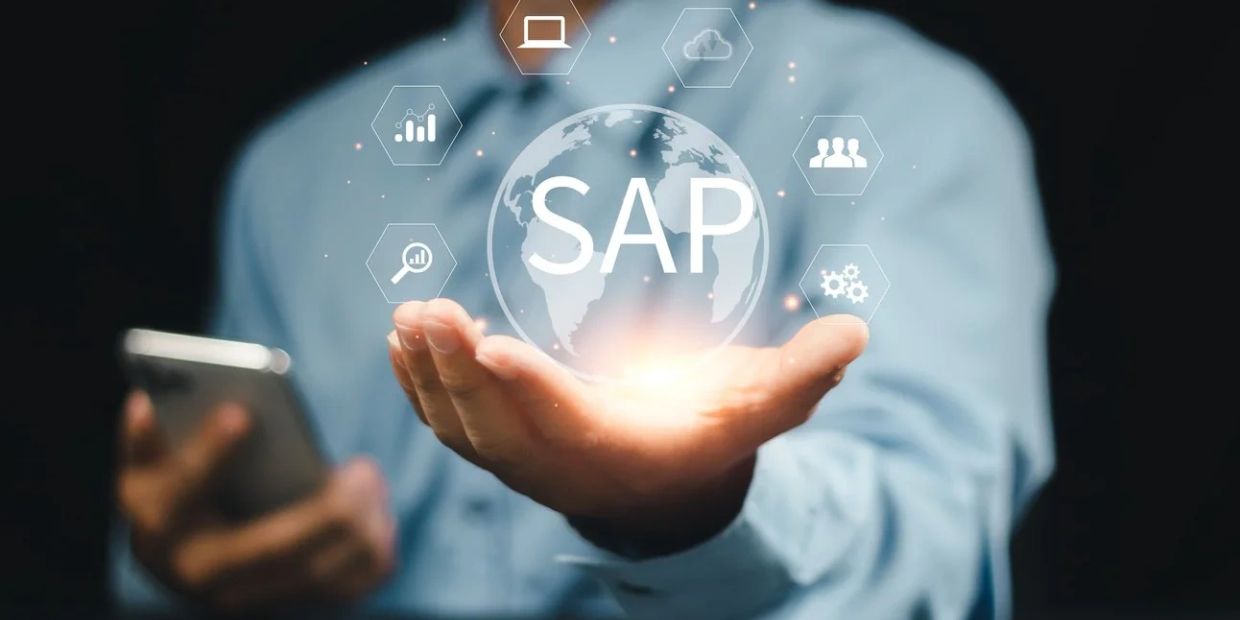 Businessman holding digital SAP globe with technology icons floating around.