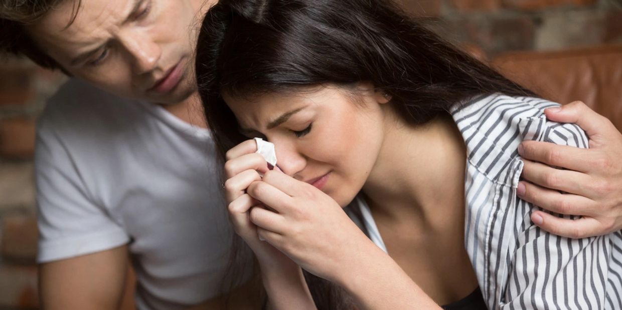 Young man comforting crying sad woman, caring friend consoling upset girl in tears