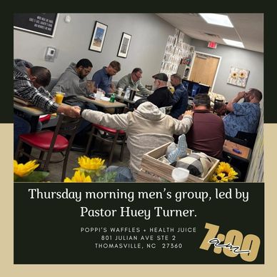 Men's group holding hands in prayer or reflection.