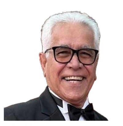 Smiling elderly man in tuxedo and glasses.