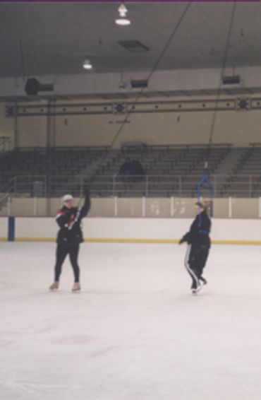 coach and figure skater training with a jump harness system