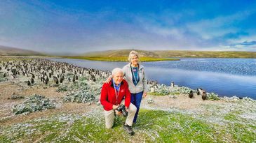 Steve and Mary with penguins at the lake on the Falkland Islands.