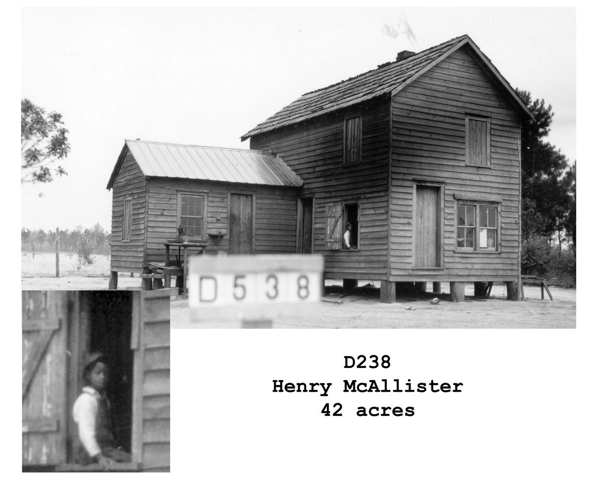 Black-and-white photo of a wooden house with a man in the window.