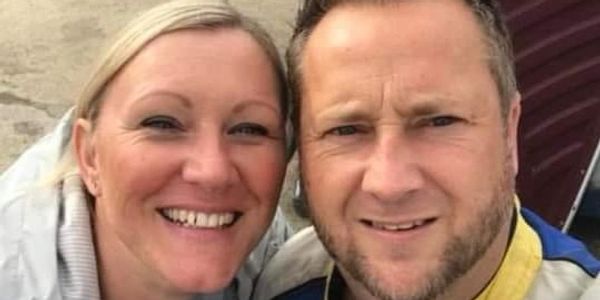 Smiling couple taking a close-up selfie outdoors.