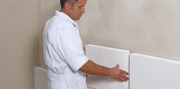 Homem aplicando isopor na parede para isolar calor