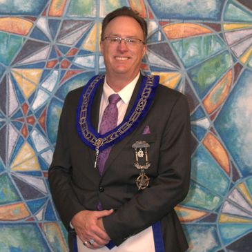 Man in formal attire with Masonic regalia.