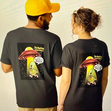 Couple wearing matching black t-shirts with a fun alien pizza design on the back.